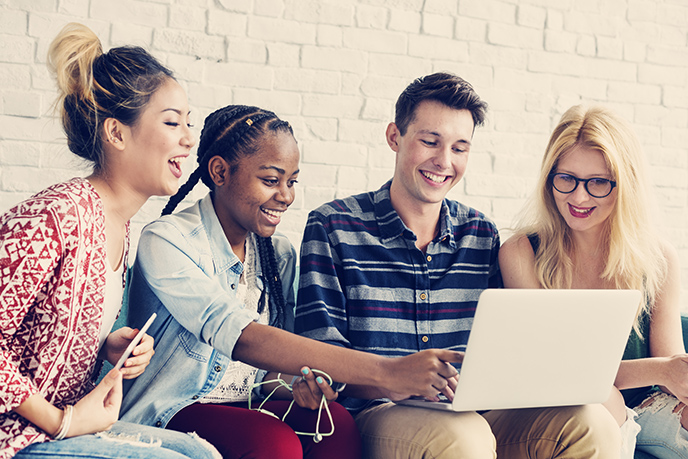 Four Friends Writing a Testimonial on Laptop